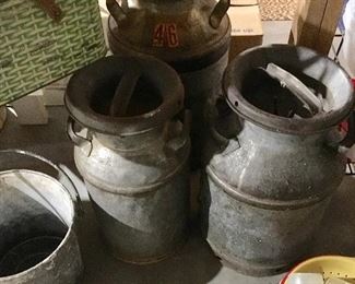 TWO OF SEVERAL VINTAGE MILK CANS.