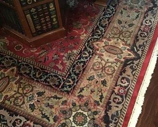 Detail of one of the many Oriental rugs, faux book table