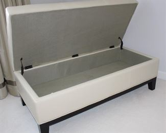 Storage ottoman shown with top open.