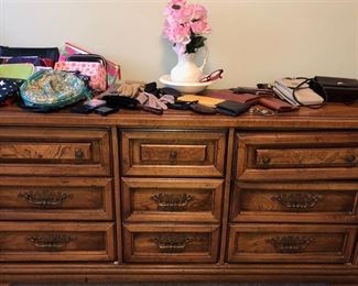 Dresser w/ women’s cosmetic bags, small purses, billfolds, gloves and flower pitcher/bowl set. Dresser is part of a queen bedroom suite. 