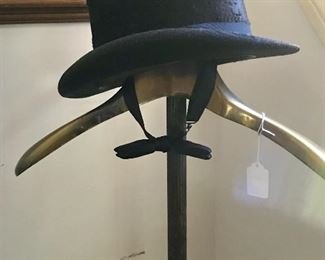 Victorian silk top hat and a brass coat rack.