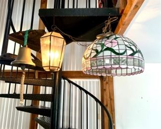 Pictured are a brass ship bell and two swag chandeliers.