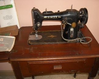 Vintage Singer sewing machine in cabinet with instruction manual and accessories