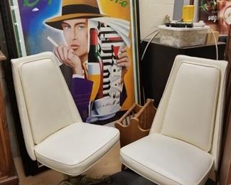 (2) Mid Century cream vinyl swivel chairs with ornate gold colored metal criss cross bases