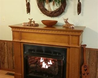 Large free standing fireplace has beautiful oak mantel and natural gas logs that are thermostat controlled.