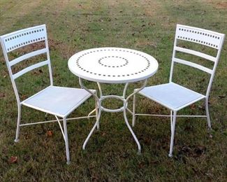 White metal bistro set.  Chairs have woven seat.