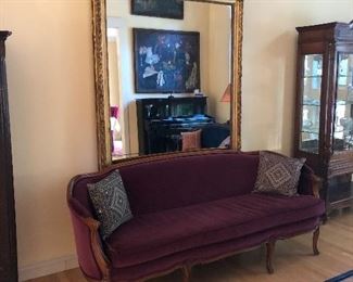 Beautiful rich velvet sofa. Behind is a large antique gilt mirror 90" high x 54" wide.