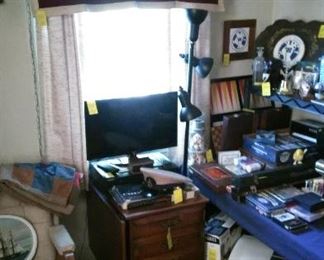 LG flat screen TV, Samsung DVD/VHS player, Drop leaf office cabinet, "BHS" (Beaver High School) banner, military items, old games.