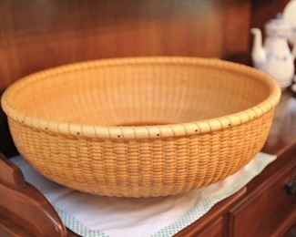 This is a large round Nantucket basket on a lazy susan base. Signed, R. Cosgray