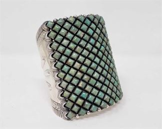 1099: Huge Amazing Native American Sterling Silver Cuff / Bracelet with Green Turquoise Stones
  This artist marked Huge Green Turquoise Cuff  Weight  approx 153.7g Approx 3" tall and 2.5" wide.. This is truly an statement piece and will add value ti your collection . This also matches the Squash Blossom Sold earlier 
Metal Type: Sterling Silver
Gemstones: Turquoise
Low Estimate: 2000.00
High Estimate: 3000.00