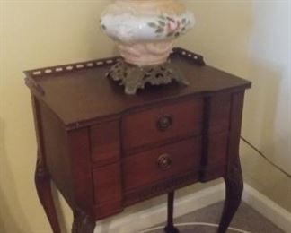 Chippendale nightstand with a Gone With the Wind lamp with brass base and floral design on base and globe.