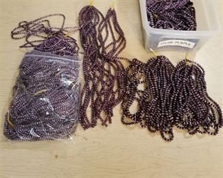 large assortment of dark purple jewelry beads on strands