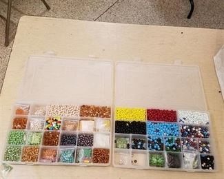two organizer containers full of assorted beads