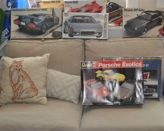 Model cars NIB Revell and more resting on an Ikea love seat.