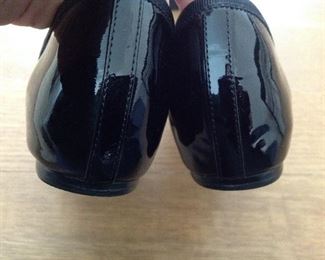 SAKS FIFTH AVENUE BLACK PATENT LEATHER FLATS WITH BOW AND 1/2" COVERED WEDGE: Size: 6.5. Grosgrain ribbon detail. Condition: Very good. Price: $100.