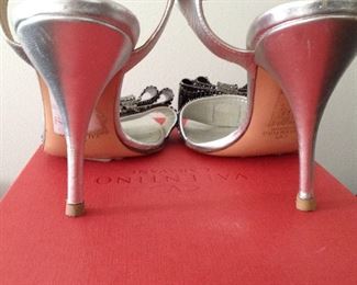 VALENTINO GARAVANI SILVER METALLIC LEATHER WITH SILVER METALLIC MESH BOWS OPEN-TOE SHOES: Size 37. Heel Height: 4 inches. Condition: Very good. Light scratches on heels. Price: $200.