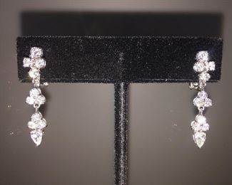 1.96 CARAT DIAMONDS AND 18K WHITE GOLD SWING DROP EARRINGS: LOTS OF FIRE AND SPARKLE.
One pair stamped & tested 18KT white gold lady's hand assembled diamond swing drop earrings.
Prong set, omega clip backs with posts and a bright polish finish Identified with markings of "18kt/750".
Condition: Excellent. Light scratches on metal.
Signed Appraisal Report included.
Total weight of diamonds: 1.96 ct.
Total weight of diamond drop earrings: 5.60 grams
Contains: Two prong set pear shaped cut diamonds (depth est.) exact total weight 2 stones = 0.41 ct. Clarity SI1 Color G Cut Excellent.
Twenty prong set round brilliant cut diamonds exact total weight 20 stones = 1.55 ct. Clarity SI-1. Color F-G. Cut: Excellent. Length of earring: Approximately One and one-quarter inch.
Width of earring: Approximately 1/4 inch at its widest.
Gift Box Included.
Price: $3,700.