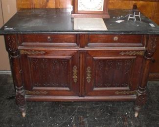 string carved mahogany linen press with black marble top