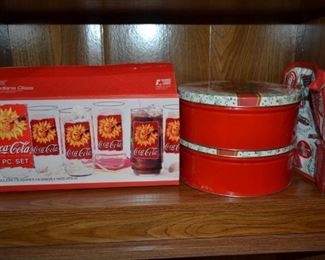 Complete set of Coca Cola glasses, oven mits, Christmas tins filled with cookie cutters.