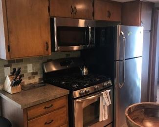 Kitchen cabinets, stainless gas range and microwave. Refrigerator not for sale.