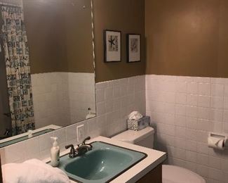 Bathroom vanity, sink, faucet, light fixture, toilet, mirror, towels