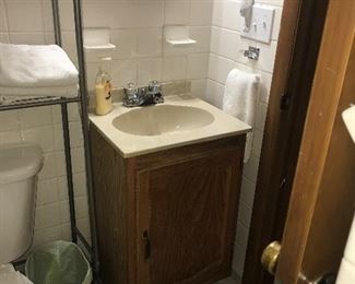 Small bathroom vanity, mirror, door, commode, rack, face plates. Everything, including the walls, is for sale!