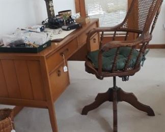 Vintage desk and early 20th century oak and cane clerks/desk chair.