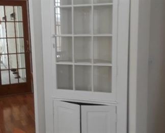 Glass front corner cabinet.