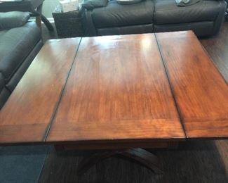 This coffee table is pictured with the sides folded out.  The two sides fold over onto the middle piece making the whole table the size of the middle piece.  This is a substantial table
