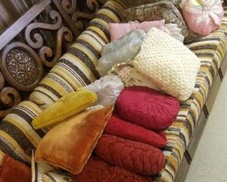 vintage sofa. Behind it is a nice king sized bed frame and headboard, lots of miscellaneous toss pillows, and a queen sized boxspring in very good condition.