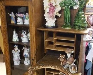 Oak secretary and lots of figurines, bells, and knick knacks.