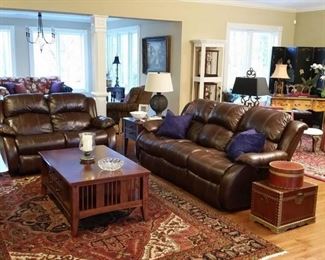 The living room features a matching leather sofa and loveseat with power recliners in each end.