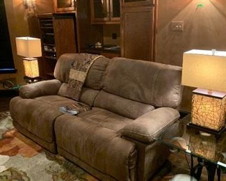 Reclining leather sofa; glass & metal tables; lamps; wall sconces; area rug