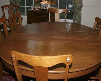 NICE OAK ROUND TABLE WITH 6 LEAVES TO SEAT 12+.  LEAVES HAVE THEIR WOODEN STORAGE  CASE