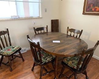 Table with 5 chairs and 2 leaves.