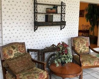 Pair of upholstered arm chairs, round accent table, decorative fireplace screen, small wall shelf, more