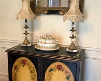 Painted two door chest with floral oval decoration,  large tureen with serving ladle, pair of gilt and glass table lamps, ornate wall mirror