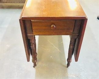 Beautiful Antique drop leaf table with brass wheels. Most likely Solid Cherry wood. 