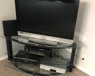 TV and TV stand. Various A/V equipment. Sold separately.