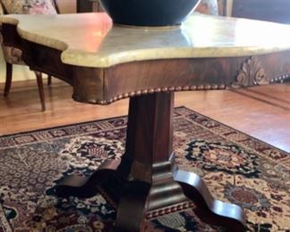 Early 19th century marble top empire style table, resting on a jewel tone area rug and resting on the table is an early 19th century cobalt blue jardinière with gold accents. 