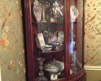 Another corner cabinet full of items.