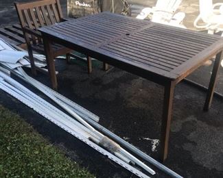 A Teak Outdoor Table.  This comes with Two End Chairs, one needs repair.