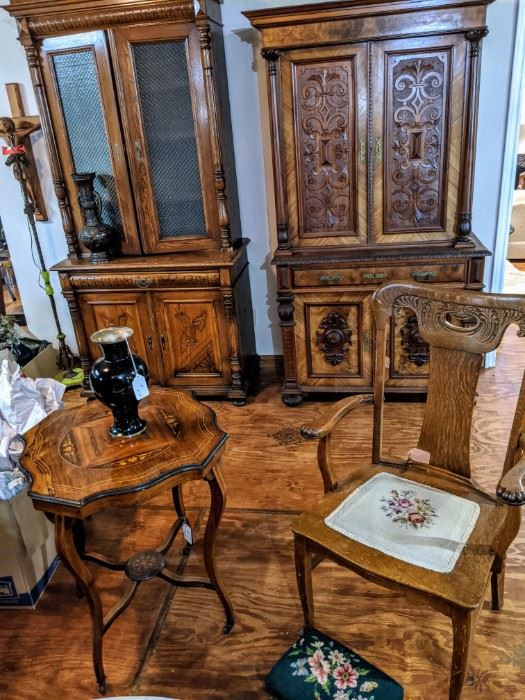 Front view of needlepoint seeded oak chair and antique refinished French inlaid Center table. Needlepoint footstool. Background is French mahogany and Walnut locking cabinet and Scandinavian cabinet. ( Left) 
