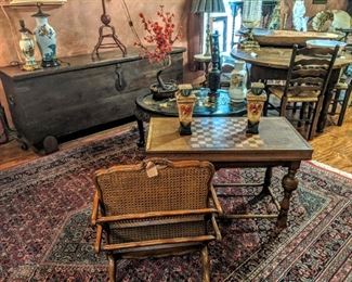 Large rustic cuff her late 1700s to early 1800s in background. Italian magazine rack in foreground with European checker table, Asian working lamps.