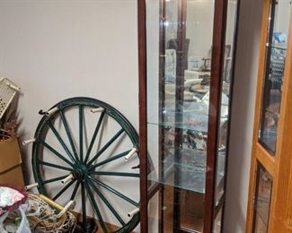 Large carriage wheel hanging light fixture and small lighted curio.