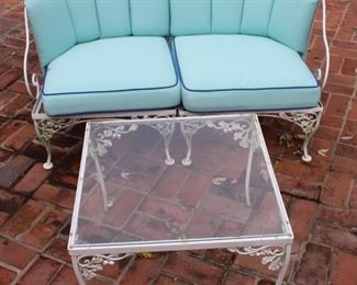 Two piece Woodard Acorn and Oak Leaf chaise shown with glass top coffee table.