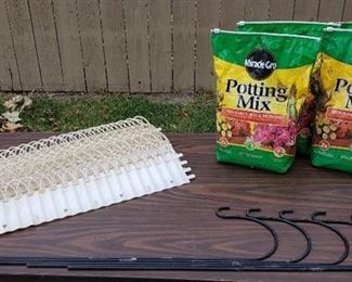 Lot of Garden Items - (16) Vintage White Plastic Edging (30 in. long) - some have slight damage, (5) Black Metal Shepherd's Hooks (36 in. tall), and (4) Bags of Potting Mix