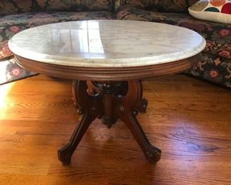 Marble top coffee table with base carved into the shape of a sweet dream
