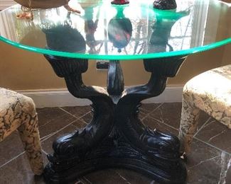 Glass top table with wood base carved into the shape of homely mermaids