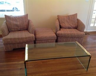 Two chairs and ottoman, plus glass coffee table.